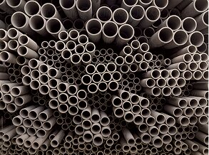 A dense arrangement of grey pipes of varying sizes, representing industrial materials and supply chain finance.