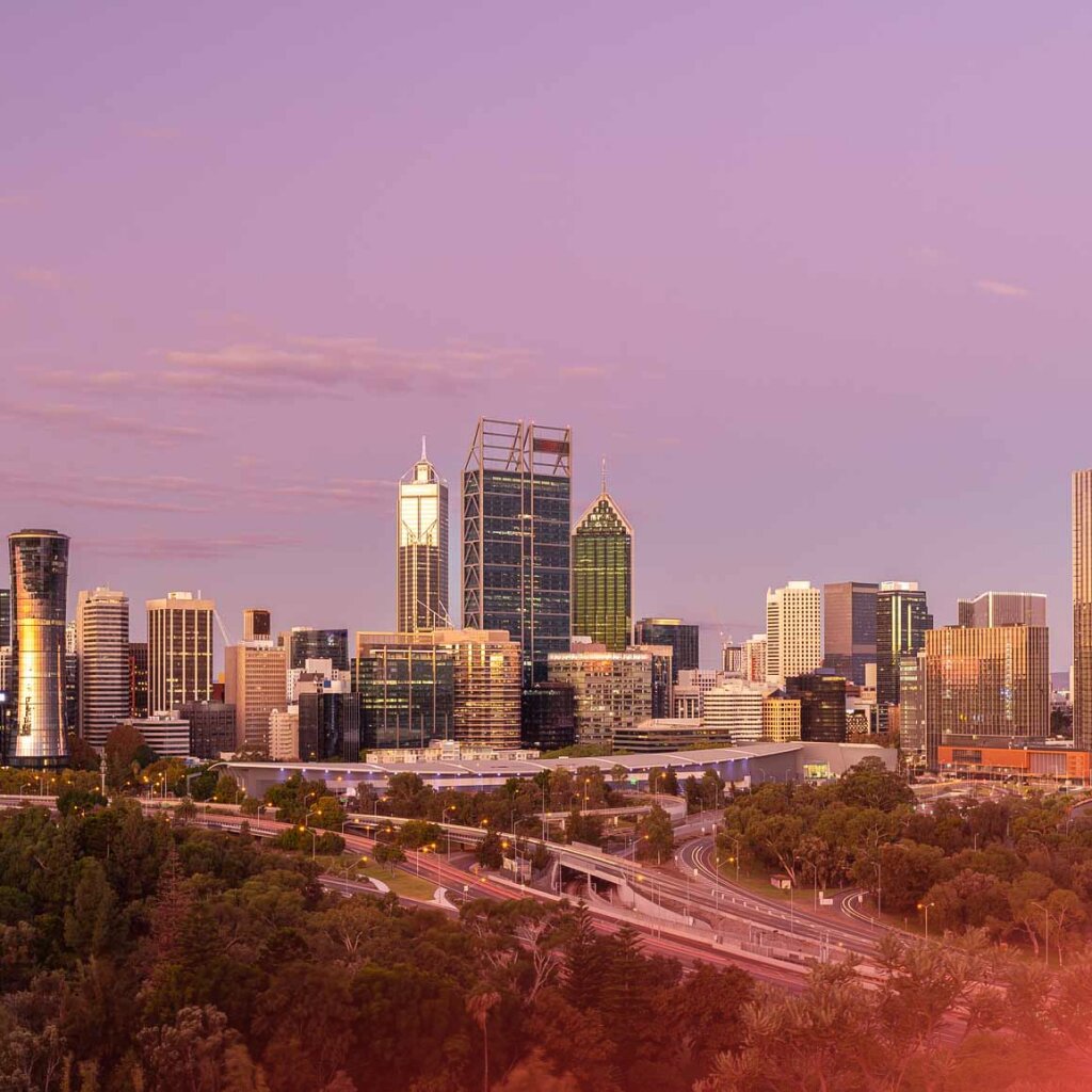The Perth city skyline at dusk, featuring modern skyscrapers and illuminated roads, symbolises Octet's Australian roots in business finance.