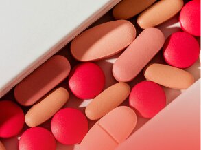A close-up view of various red and peach-coloured pills and tablets, symbolising the pharmaceutical industry's need for robust business finance.