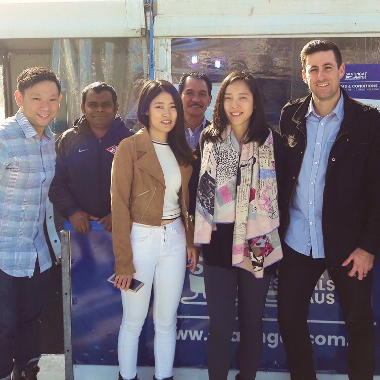 Six diverse Octet staff members smile at an outdoor ice skating event, reflecting a positive team culture.