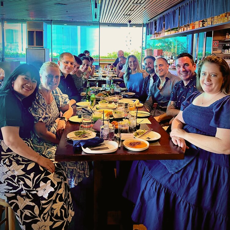 A group of smiling Octet team members enjoying a dinner together, reflecting the company's vibrant culture.