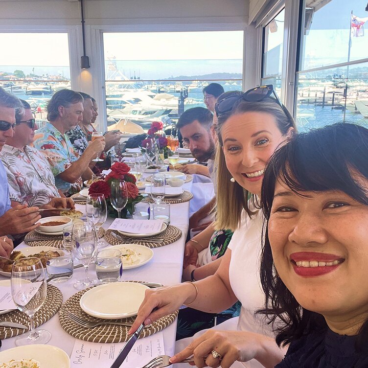 Octet team members enjoy a social lunch at a restaurant overlooking a marina, promoting a positive work culture.